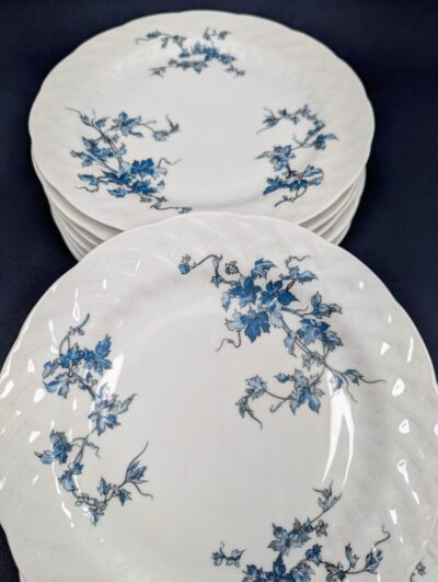 Pile d'assiettes à dessert en porcelaine blanche de Limoges avec bordure frise dorée modèle Saint-Saëns
