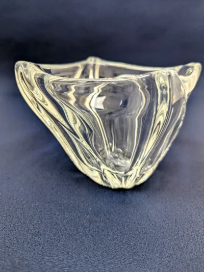Coupelle vide-poche en cristal Daum France de forme organique, design moderne épuré avec signature gravée, objet de collection en cristal transparent.