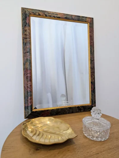 Grand miroir vintage des années 80 avec cadre en bois au décor floral de roses sur fond noir, liseré doré et glace biseautée authentique.