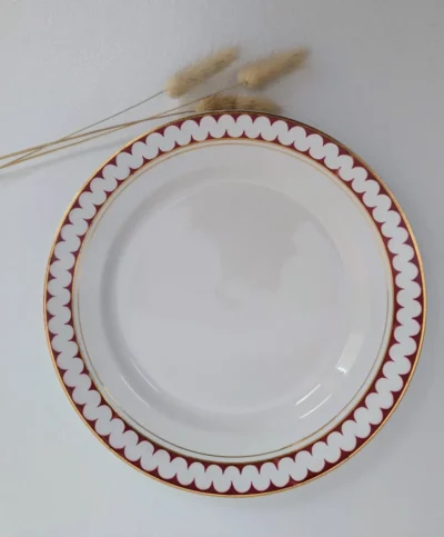 Service de 6 assiettes plates anciennes Lunéville modèle Madrigal en porcelaine, décor de motifs oscillants rouge et or, diamètre 23 cm.