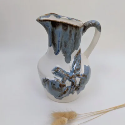Broc en céramique blanc et bleu signé Rhoda