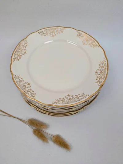 Service de 10 assiettes plates vintage Villeroy & Boch modèle Rhône, porcelaine ivoire avec décor d'arabesques dorées, diamètre 23 cm.