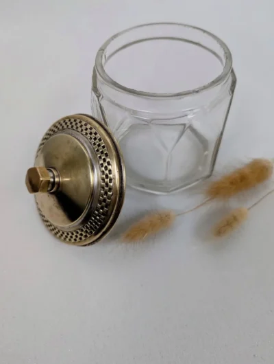 Sucrier ancien composé d'un récipient en verre transparent facetté et d'une monture avec couvercle en métal doré travaillé.
