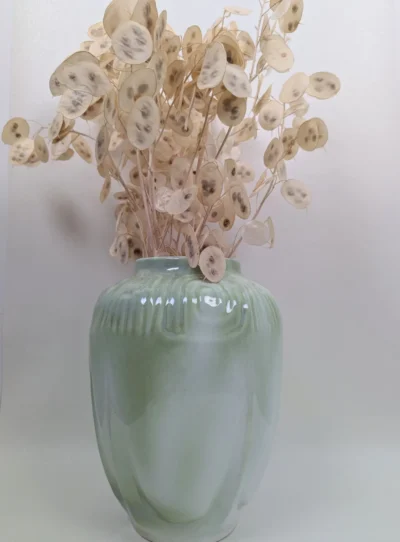 Vase Art Nouveau en barbotine vert amande de 27 cm, décor floral en relief et silhouette organique, céramique française ancienne du début du XXe siècle.