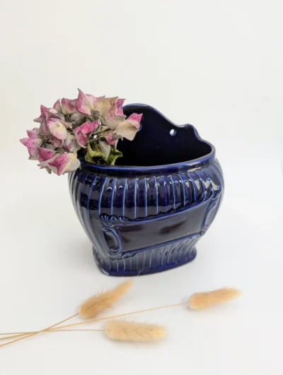 Porte sel mural vintage en céramique bleu de four avec motifs de côtes en relief et bouquet d'hortensias séchés