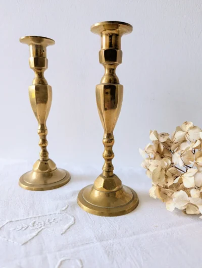 Paire de bougeoirs vintage en laiton doré à silhouette élancée, hauteur 22 cm, chandeliers anciens avec patine naturelle pour décoration de table chic.
