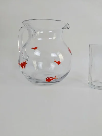 Broc en verre soufflé artisanal avec inclusions de six poissons rouges dans la paroi, pichet transparent original style Murano pour art de la table vintage.