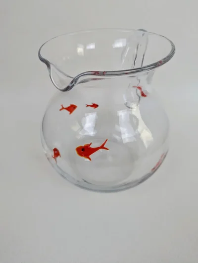 Pichet en verre soufflé transparent avec inclusions artisanales de poissons rouges et décors de bulles d'air.