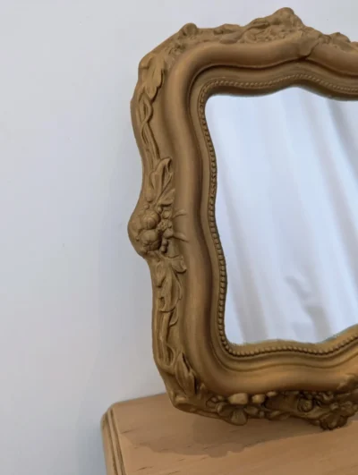 Miroir rond vintage avec cadre en plâtre doré et décor sculpté en relief de volutes et coquilles