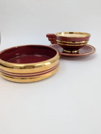 Duo Art Déco en céramique rouge bordeaux et dorure à l'or fin comprenant une tasse avec sa soucoupe et un sucrier assorti.