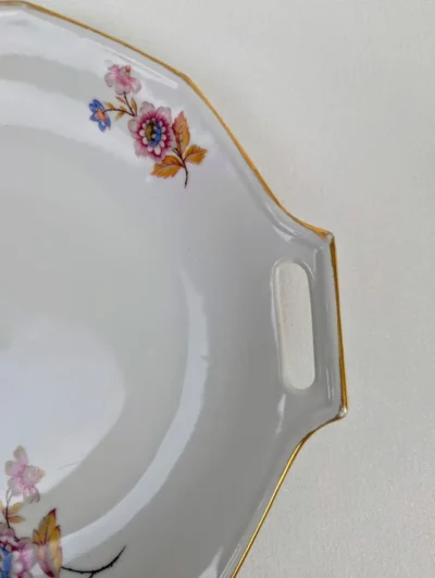 Grand plat à tarte rond en porcelaine de Limoges (PFC) au décor printanier de fleurs sauvages bleues et roses avec bordure dorée.