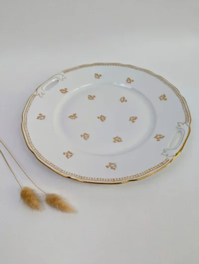 Plat à tarte ancien en porcelaine de Limoges blanche avec liseré doré et motifs de petites fleurs dorées, anses ajourées.