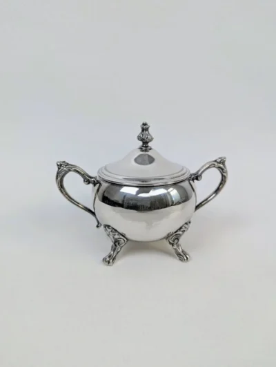 Sucrier vintage en métal argenté Sheffield de style victorien, quatre pieds sculptés, anses ciselées et bouton de couvercle en forme de fleur.