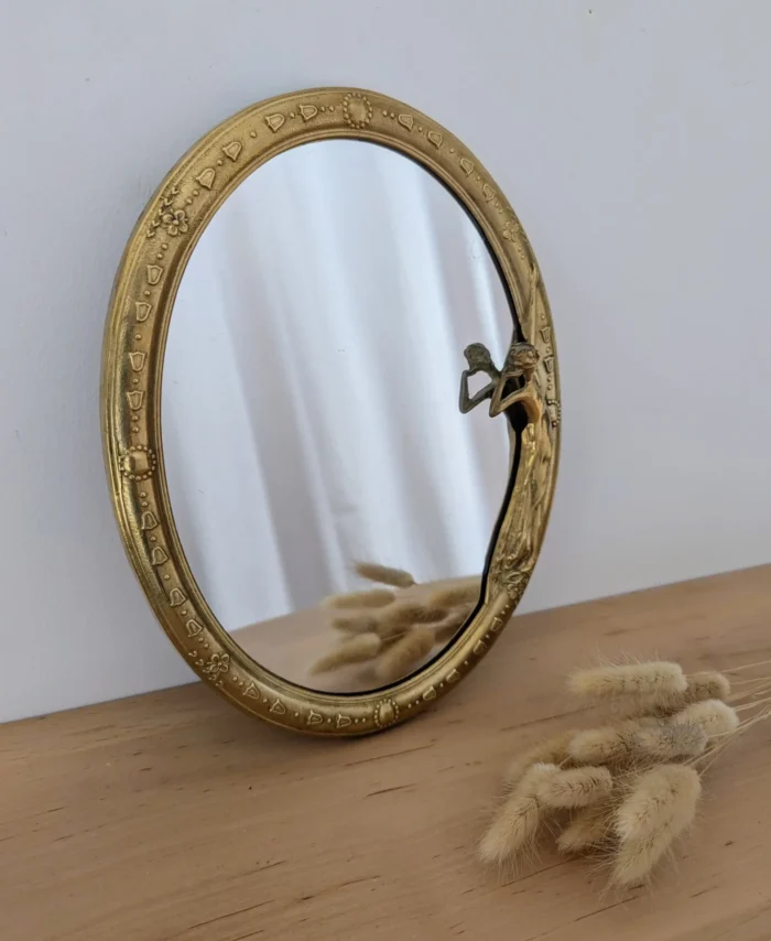 Miroir ovale de style Art Nouveau en laiton doré.