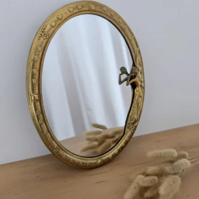 Miroir ovale de style Art Nouveau en laiton doré.
