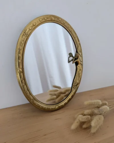 Miroir ovale de style Art Nouveau en laiton doré.