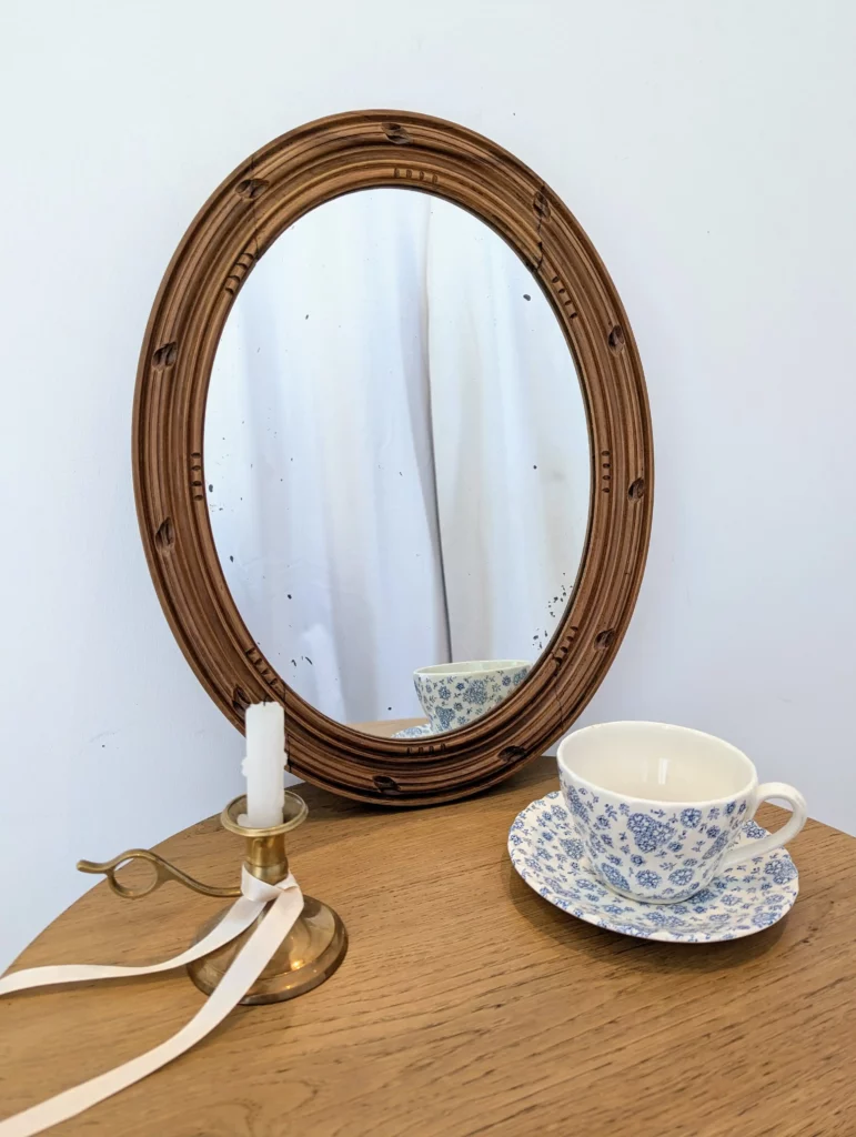 Miroir ancien ovale en bois sculpté patiné pour une décoration slow déco