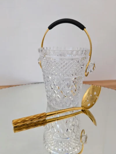 Seau à glaçons vintage en verre taillé à facettes, anse mobile dorée et cuillère à glaçons assortie, style cocktail bar des années 60.