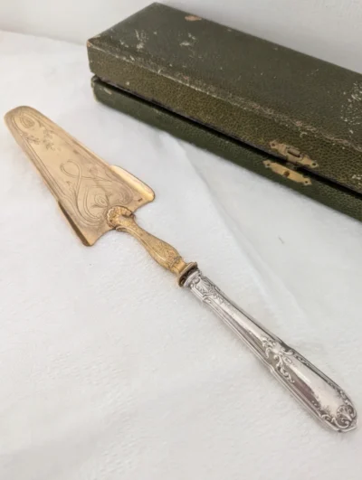 Pelle à tarte ancienne en métal argenté et vermeil doré, gravures florales artisanales, longueur 26 cm avec écrin d'origine.