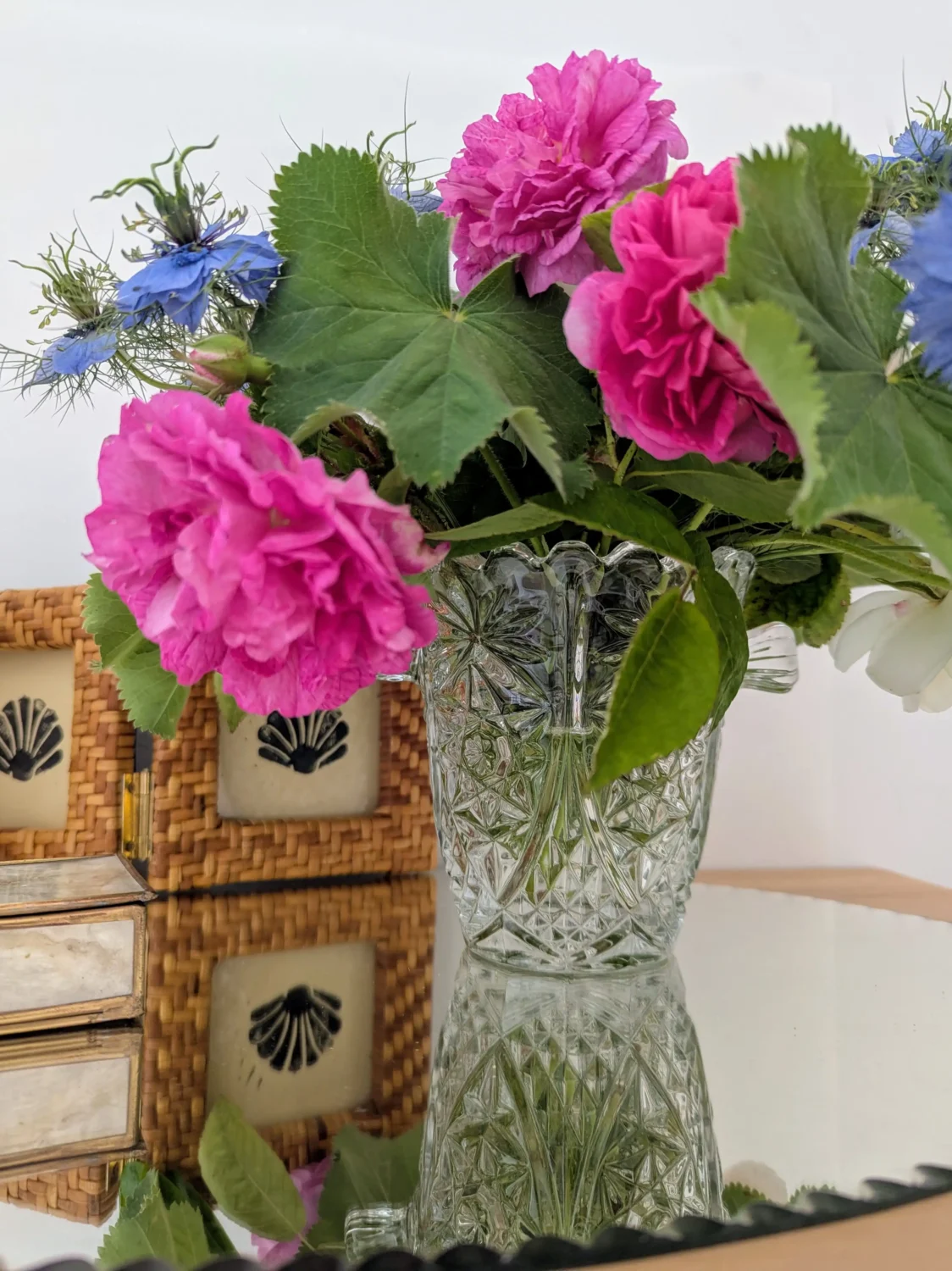 Décoration vintage avec cadre triptyque en rotin tressé, vase en cristal et bouquet de fleurs fraîches – inspiration Villa Brieg