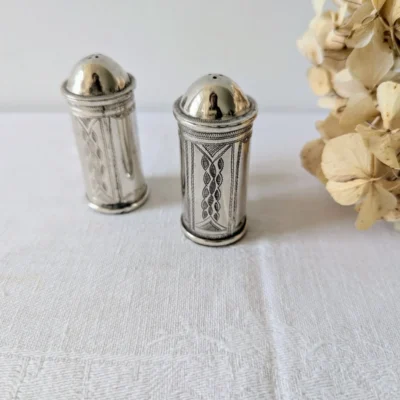 Salière et poivrière anciennes en métal argenté avec fleurs séchées