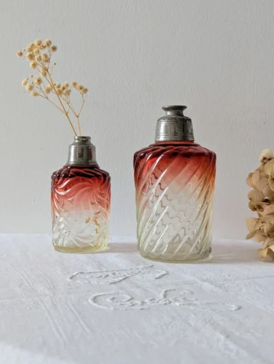 Duo de flacons de toilette anciens en verre moulé torsadé avec dégradé rouge rubis et montures en métal argenté patiné.