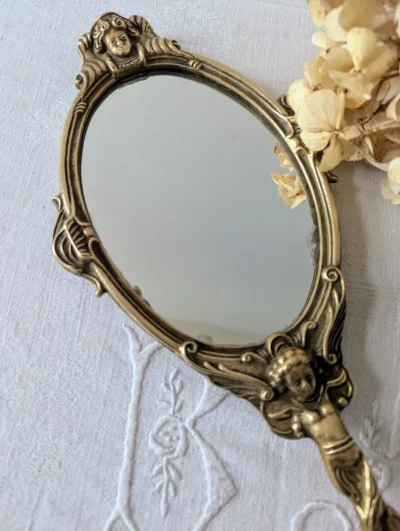 Miroir à main ancien en bronze patiné avec décor d'angelots sculptés, accessoire de coiffeuse vintage 30x14 cm.