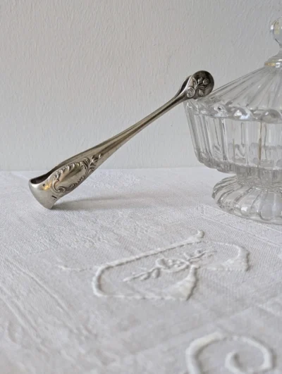 Pince à sucre ancienne Christofle en métal argenté modèle Rocaille, décor ciselé style Louis XV avec coquilles et volutes, orfèvrerie française de collection.