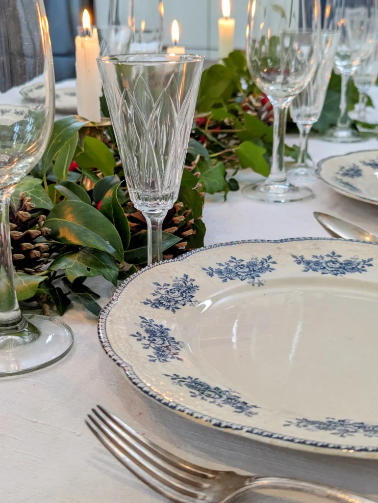 Table de Noël chic dressée avec vaisselle ancienne, bougeoirs dorés et verres en cristal, signée Villa Brieg