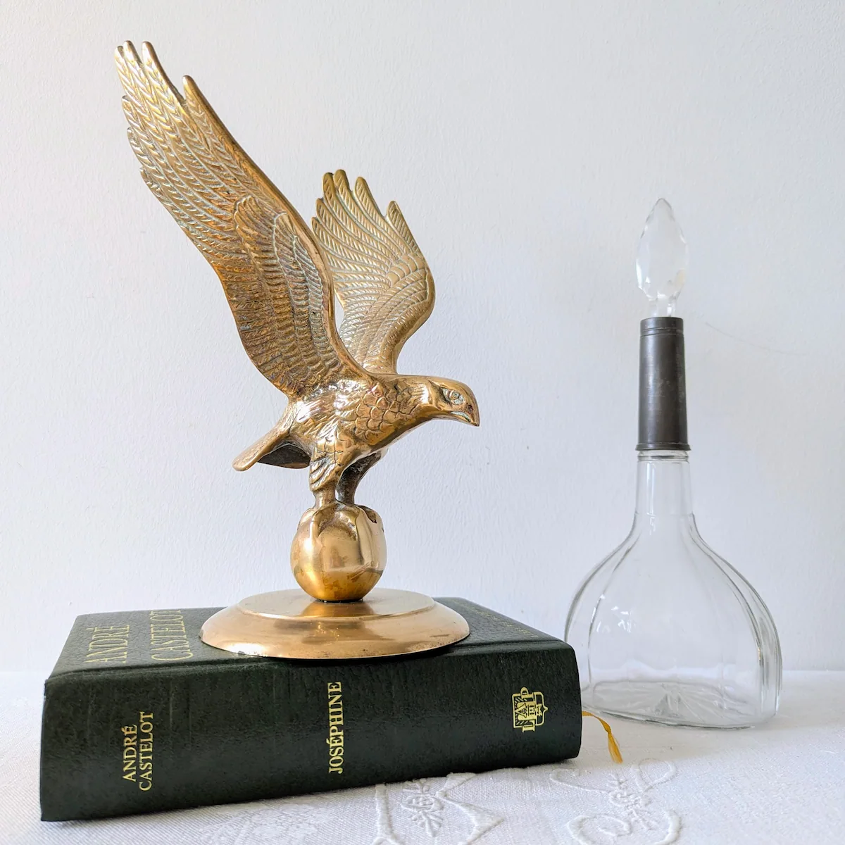 Aigle ancien en laiton posé sur un livre vert Josephine