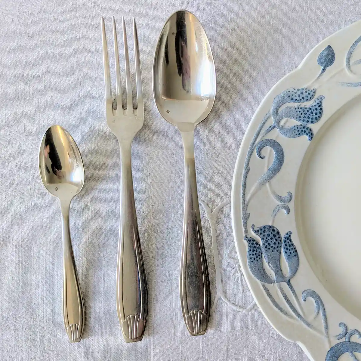 Mise en scène ménagère ancienne métal argenté sur table contemporaine