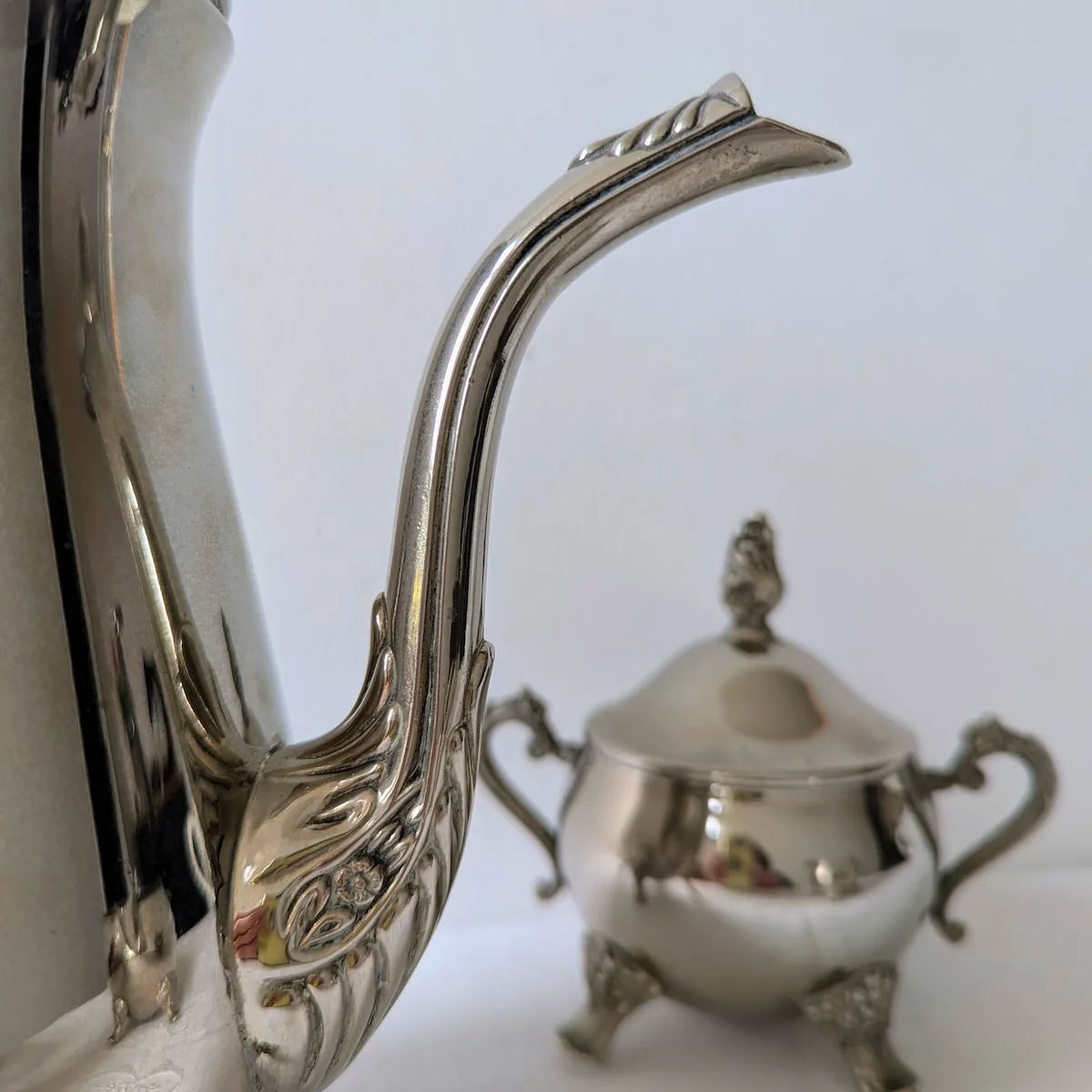 Détail du bec verseur ciselé et motif floral service argenté