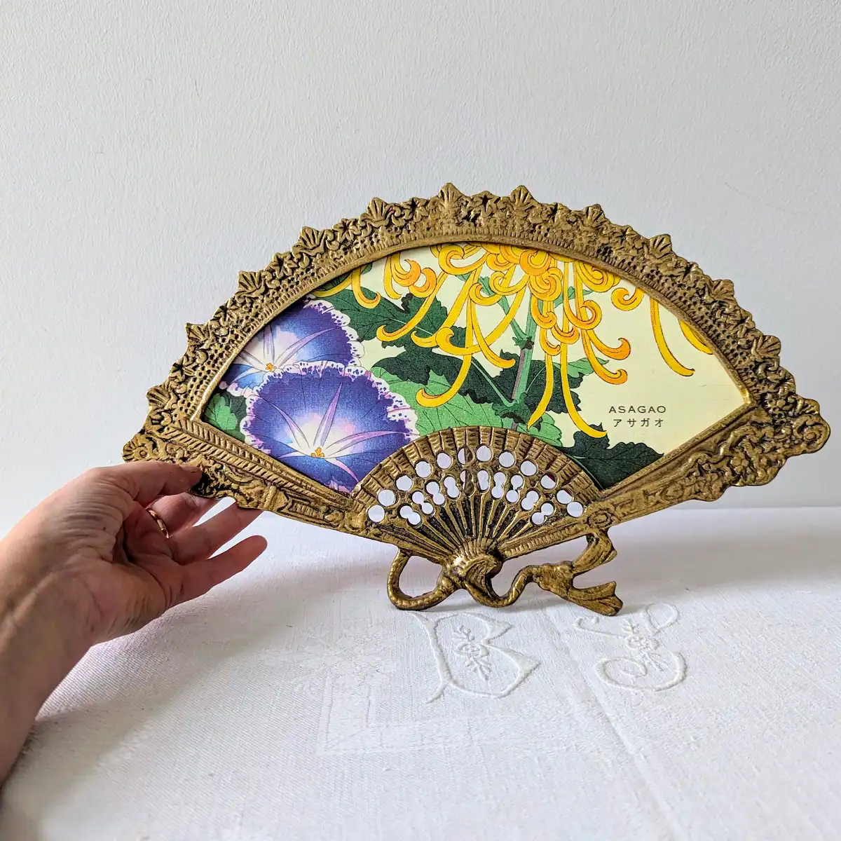 Main tenant le cadre éventail ancien pour donner l'échelle