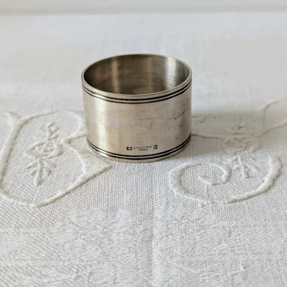 Détail des poinçons d'authenticité Christofle sur rond de serviette ancien.