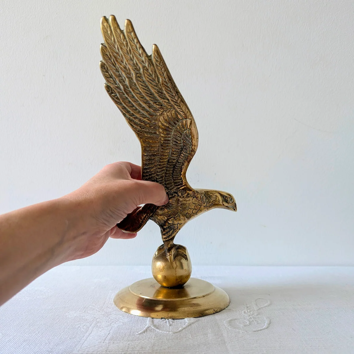 Main tenant l'aigle en laiton pour montrer la taille