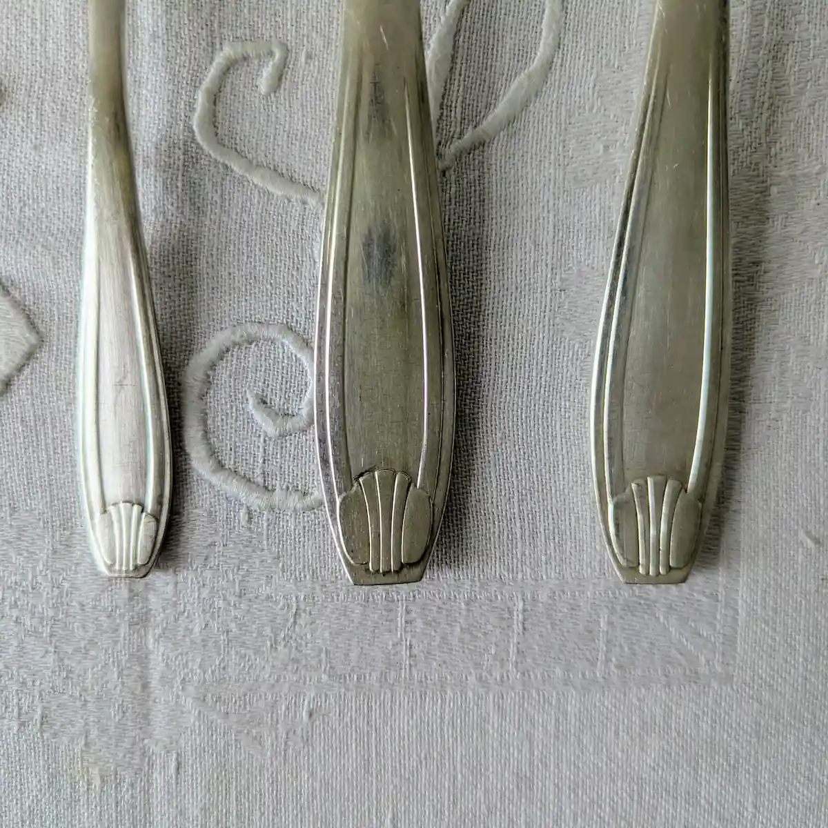 Détail motif coquille sur manche de ménagère ancienne métal argenté