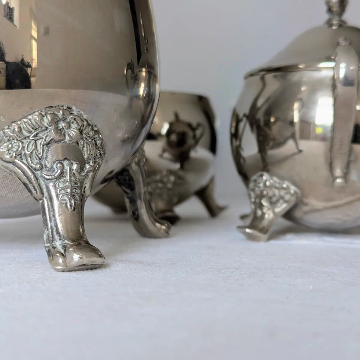 Zoom sur les pieds griffes et motifs fleurs du sucrier ancien