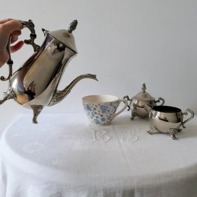 Action de verser le café avec cafetière ancienne métal argenté