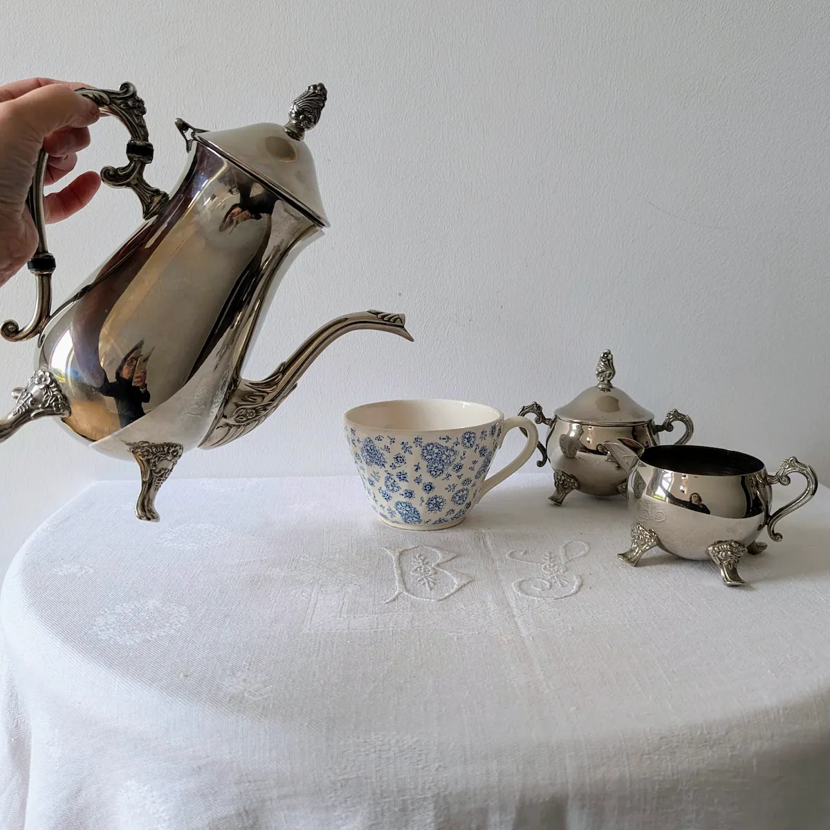 Action de verser le café avec cafetière ancienne métal argenté