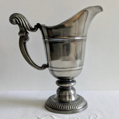 Aiguière en étain ancienne modèle casque sur fond blanc