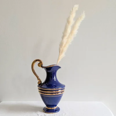 Carafe ancienne utilisée comme vase avec des fleurs de pampa