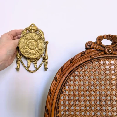 Patère ancienne laiton mise en scène sur fond cannage