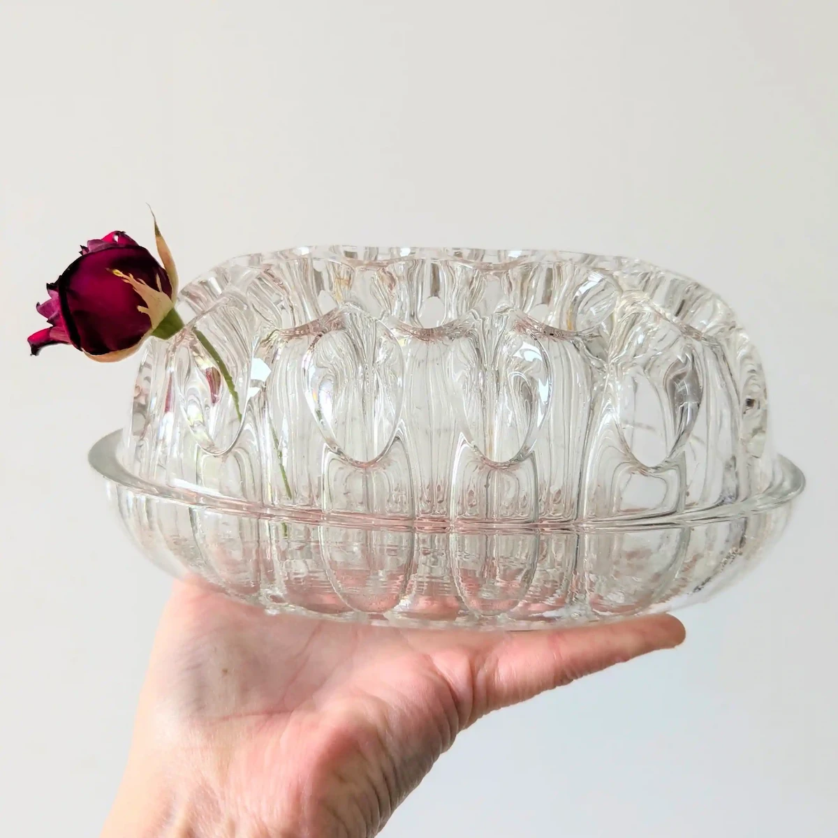 Main tenant le pique-fleurs en verre pour montrer sa taille réelle