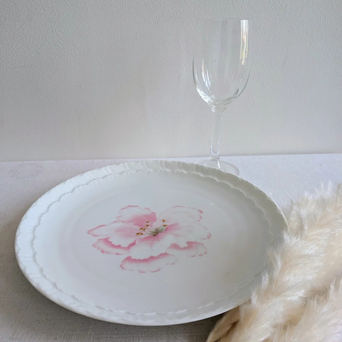 Assiette Limoges décorative sur table avec verre à pied