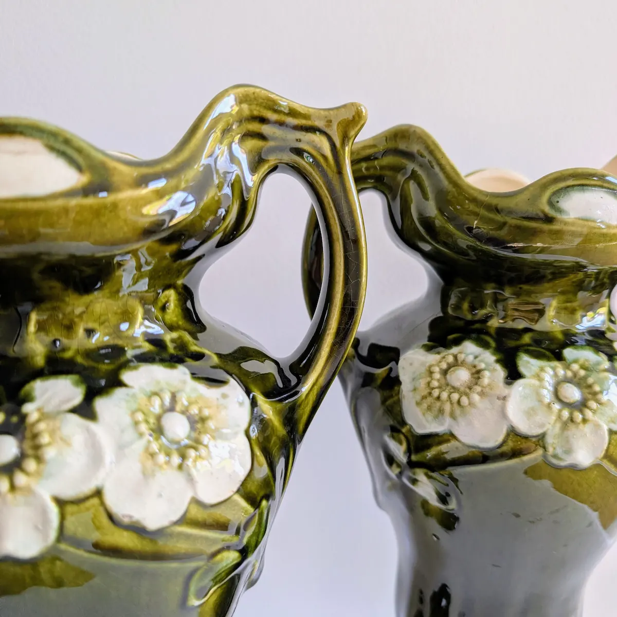 Zoom sur le col ondulé et l'émail nuancé d'un vase ancien vert