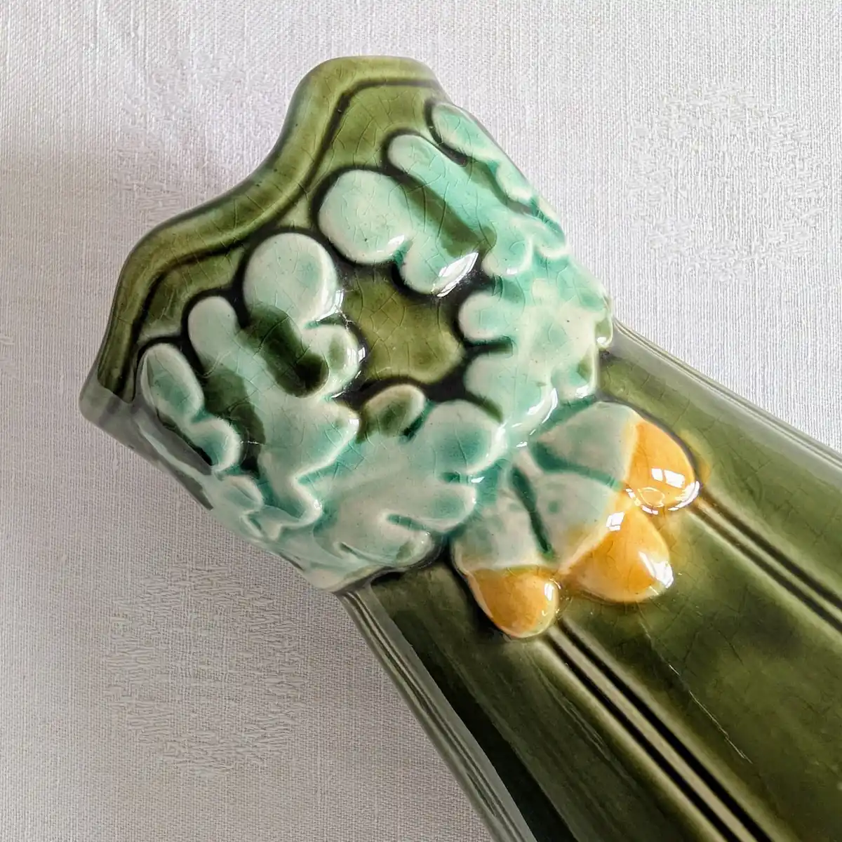 Gros plan sur le marquage du vase barbotine feuilles chêne