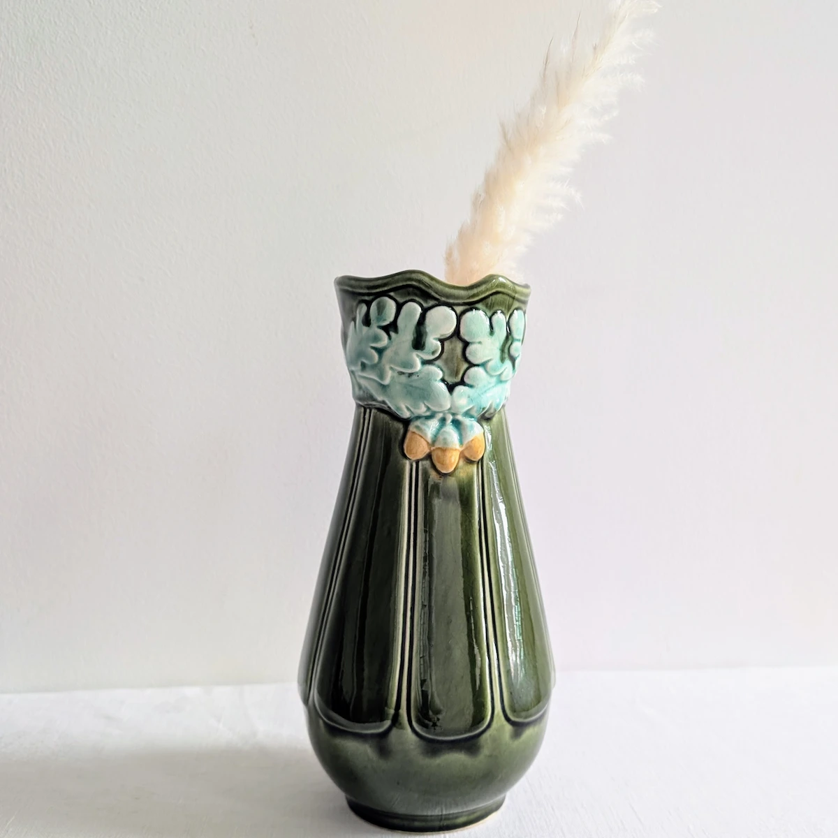 Vase ancien en barbotine verte vu de dos décor chêne