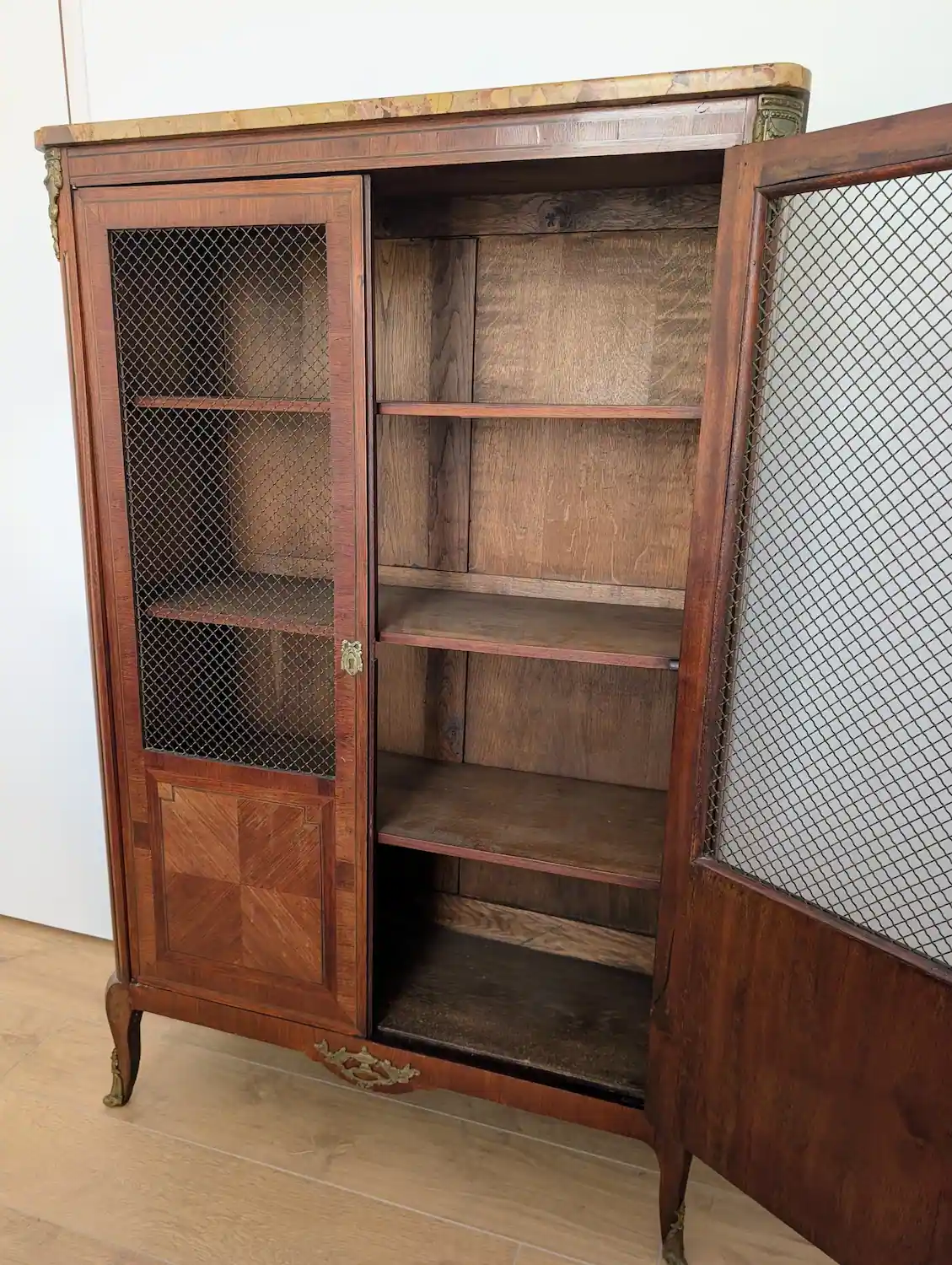 Intérieur d'une bibliothèque ancienne avec trois étagères en bois massif et portes ouvertes