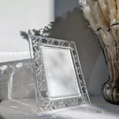 Cadre en verre ancien captant la lumière du soleil sur une console