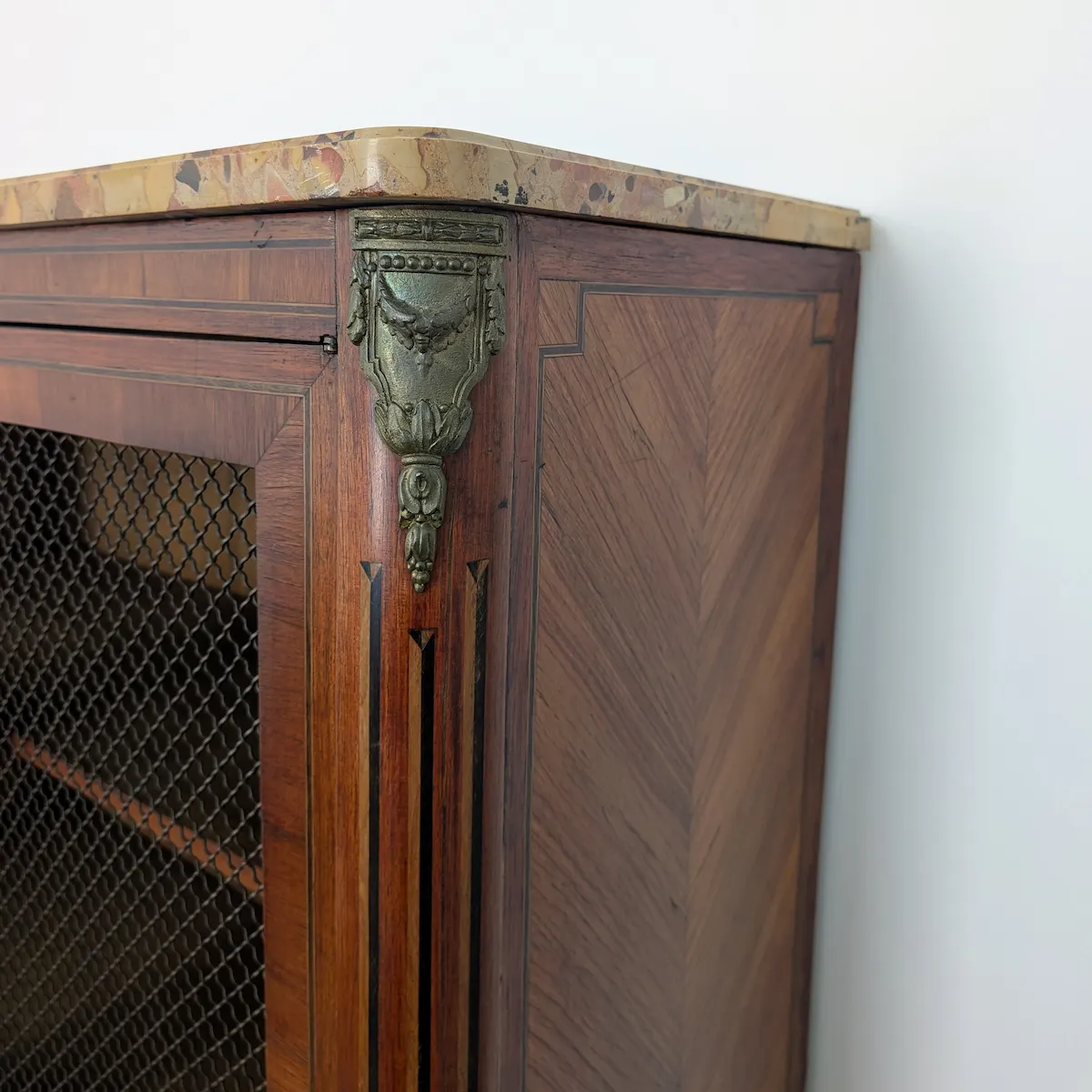 Vue de profil du meuble montrant le placage en ailes de papillon sur le côté